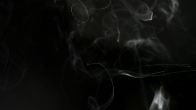 Smoke slow floating in space against black background. 4K UHD.