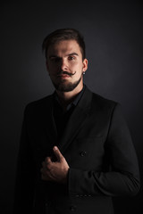 Fototapeta premium handsome brutal guy with beard on dark background