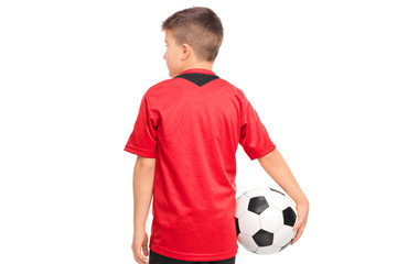 Junior soccer player holding a ball isolated on white background