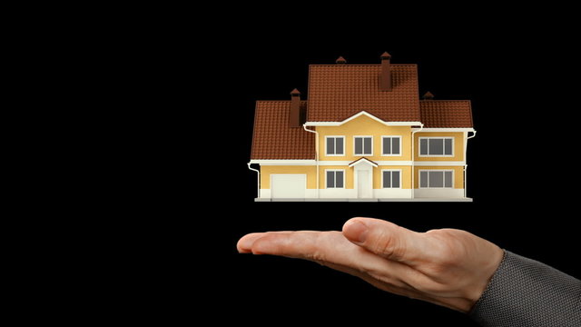 Futuristic Presentation. A holographic 3D-model of a modern house exterior cyclically rotating above the facing up palm of a male hand. Video and graphic compositing.