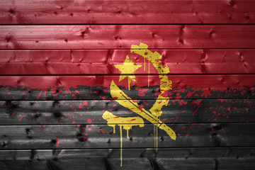 painted angolan flag on a wooden texture