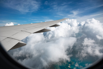 Fototapeta na wymiar Wing of airplane flying above the clouds