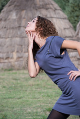 Woman posing and enjoying the moment front of straw houses