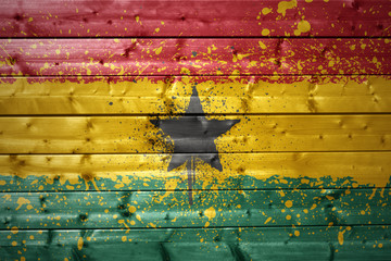 painted ghanaian flag on a wooden texture