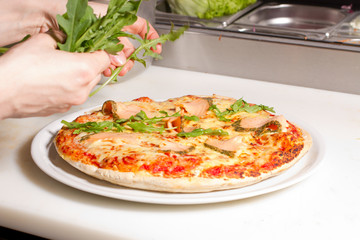 Pizza mit Rucola belegen