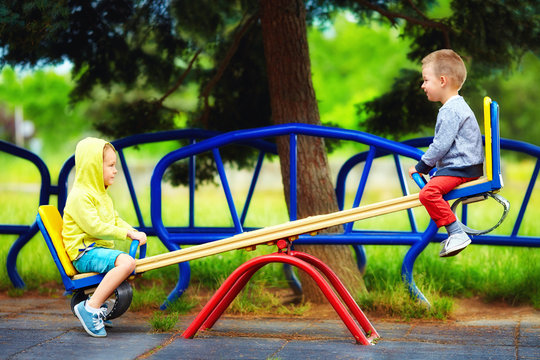 cute kids having fun on seesaw at playground