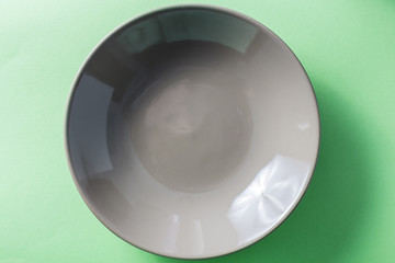 Brown empty bright dish on a green background