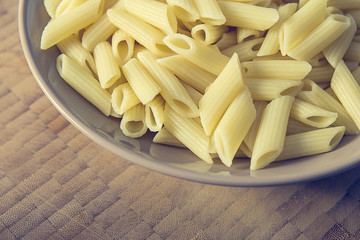 Pasta food on a brown bowl and diagonal pattern wood background