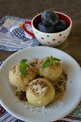 Dumplings stuffed with plums and sprinkled with cocoa nad grated almonds
