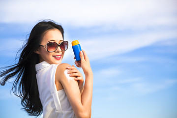 young woman applying sun protection lotion