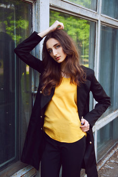 Young Woman Portrait In Black Trenchcoat And Yellow Blouse