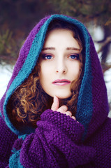 Mysterious young woman in purple cape with a hood