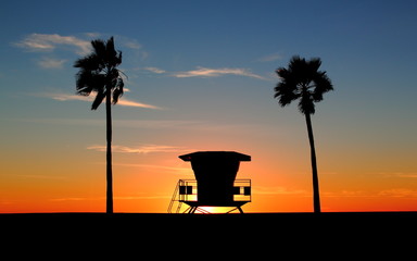 Silhouette of a California life guard station at sunset with Palm Trees