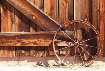 Obraz premium Wood Barn Doors – Front entrance of an old wooden farmhouse barn doors with metal wagon wheel 