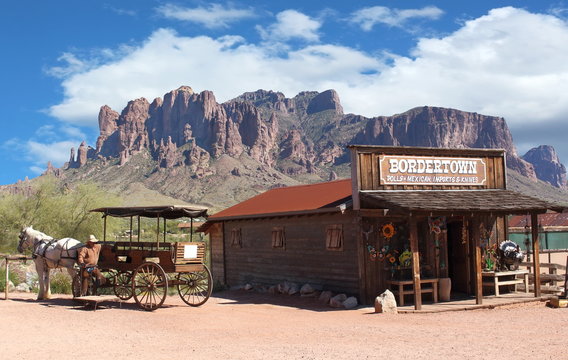 Old Wild West Cowboy town with horse drawn carriage and mountains in background