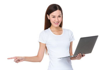 Asian woman hold with laptop computer and finger point aside