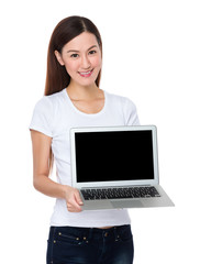 Naklejka premium Young woman show with the blank screen of laptop computer