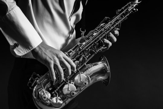 A man plays the saxophone close up.