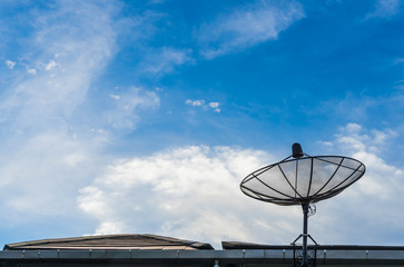 A black satellite dish on blue sky background