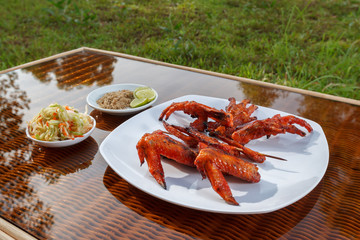 Grilled chicken on white plate with parsley, salad and beer outdoors