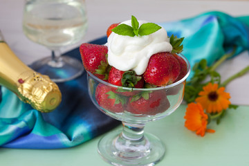     Strawberries with whipped cream, champagne and flowers