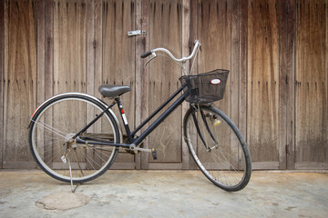 Fototapeta na wymiar Vintage Bicycle standing near a vintage wood wall