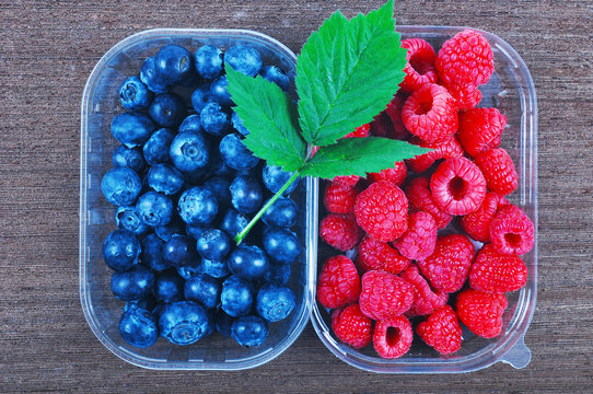Blueberries and raspberries in plastic boxes