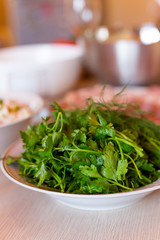 green fresh bunch of parsley and dill lying on the plate for decoration of dishes