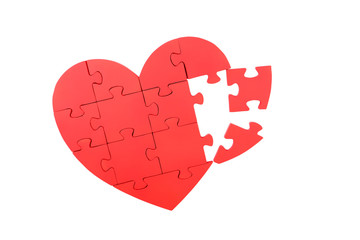 Red puzzle heart isolated on white
