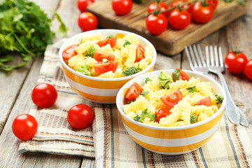Delicious pasta in bowl on grey wooden background