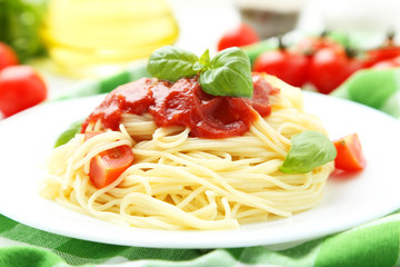 Spaghetti with tomatoes and basil on plate 