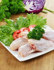 Raw chicken legs on wooden