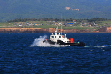 towing the ship breaks the sea wave case on the background of the steep banks of wood