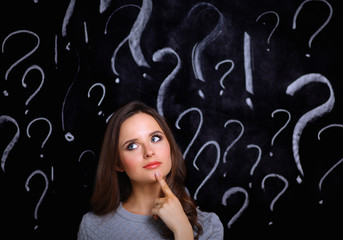 Young girl with question mark on a gray background
