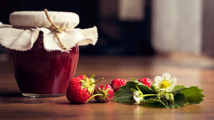 Fototapeta na wymiar Homemade strawberry jam (marmelade) in jars on wooden background.