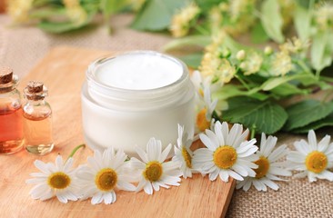 Fototapeta na wymiar jar of natural organic cream cosmetic product fresh flowers chamomile linden herbs, essential oils,spa