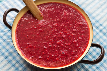 Homemade strawberry jam (marmelade) cooking. Large pot with hot jam