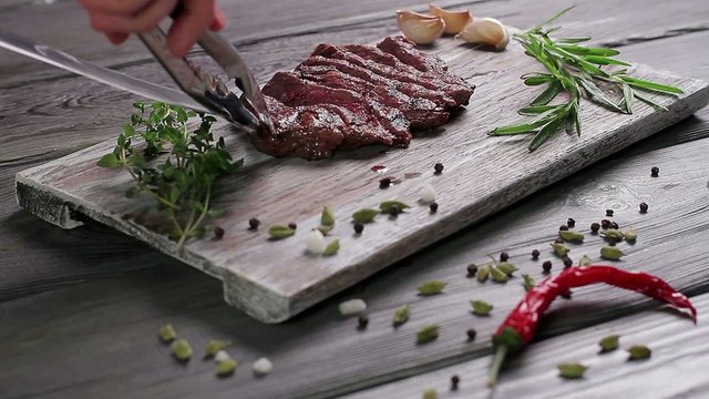 Chef lays out nice steak on a wooden board.