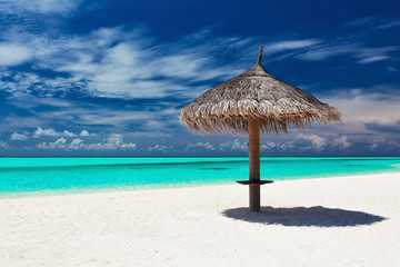 Single tropical beach umbrella on romantic white beach