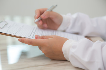 Hand of doctor writing on prescription