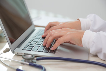 Doctor hands typing on laptop keyboard