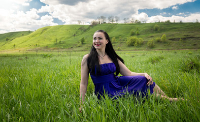 brunette woman lying on meadow and looking at sky
