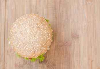 Tasty cheeseburger with lettuce, beef, double cheese and ketchup. From above view as background.