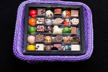 Set of a various chocolate pralines in lavender basket