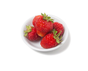 Strawberries with tails on a saucer. Isolated on white backgroun
