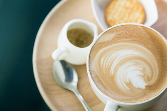 Hot latte art coffee on table ( Filtered image processed vintage