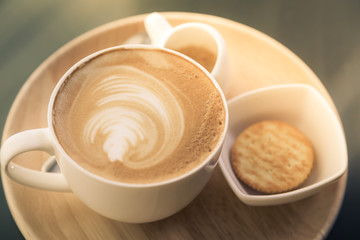 Hot latte art coffee on table ( Filtered image processed vintage