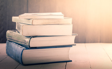 stack of old books on wooden table,vintage color filter