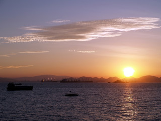 dawn sunrise and silhouette of cargo ships, first light of day over the massif on koh sichang island, Thailand