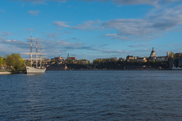 Sailing ship is in foreground of Skeppsholmen islands at evening, Stockholm, Sweden.